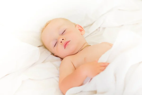Huzurlu bebek bir yatakta uyuyan yalan — Stok fotoğraf
