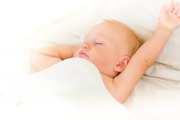 Bebê tranquilo deitado em uma cama dormindo — Fotografia de Stock