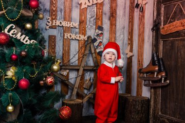 Noel Baba'nın kostüm Xmas ağacı yakınındaki mutlu küçük bebek