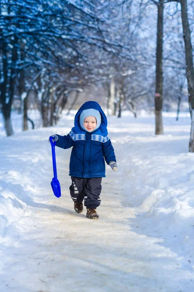 Bonito menino brincando com pá de brinquedo de neve — Fotografia de Stock