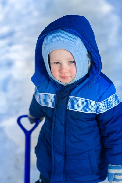 Bonito menino brincando com pá de brinquedo de neve — Fotografia de Stock