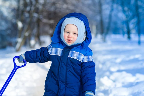 Bonito menino brincando com pá de brinquedo de neve — Fotografia de Stock