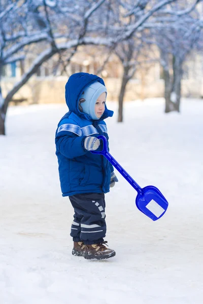 Bonito menino brincando com pá de brinquedo de neve — Fotografia de Stock