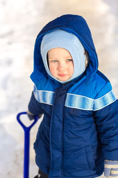 Bonito menino brincando com pá de brinquedo de neve — Fotografia de Stock