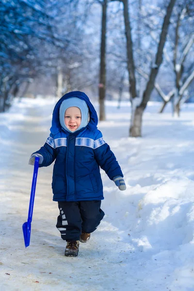 Bonito menino brincando com pá de brinquedo de neve — Fotografia de Stock