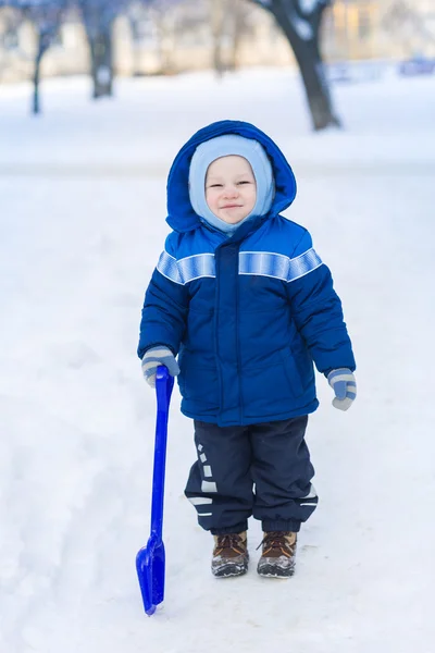 Bonito menino brincando com pá de brinquedo de neve — Fotografia de Stock