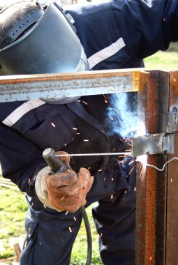 Metal bir parçayı kaynaklayan kaynakçı.