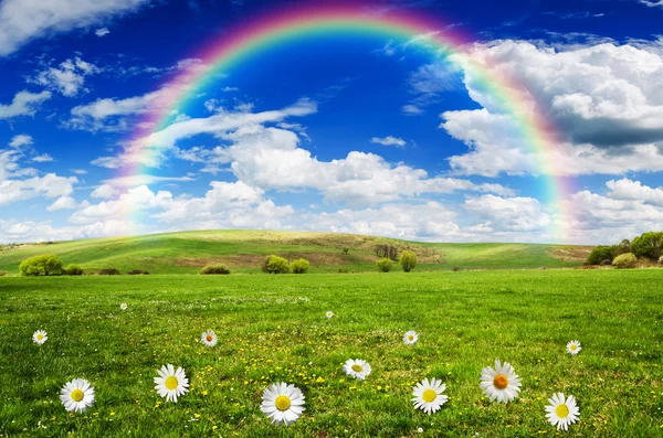 Sunny day with rainbow and fluffy white clouds — Stock Photo, Image