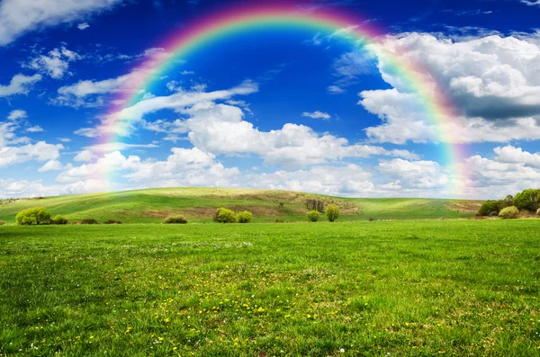 Giornata soleggiata con arcobaleno e soffice nuvole bianche — Foto Stock