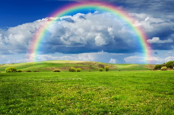 Día soleado con arco iris y nubes blancas esponjosas — Foto de Stock