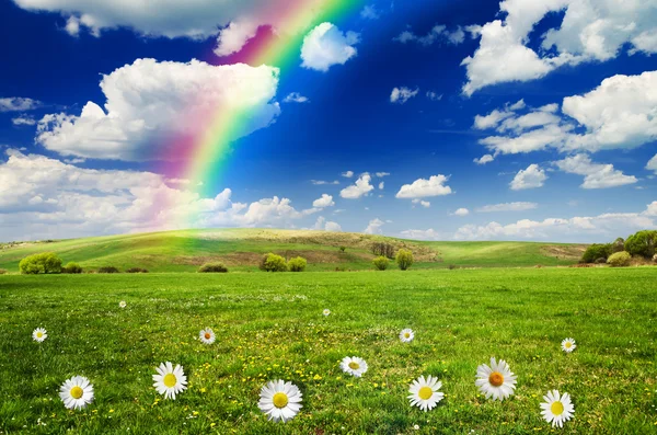 Sunny day with rainbow and fluffy white clouds — Stock Photo, Image