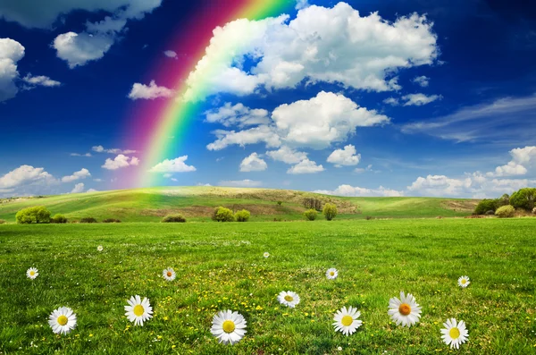 Sunny day with rainbow and fluffy white clouds — Stock Photo, Image