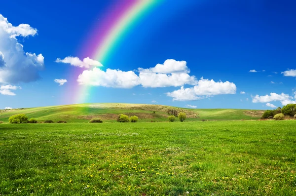 Día soleado con arco iris y nubes blancas esponjosas — Foto de Stock