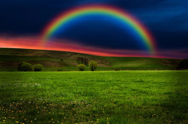 Hermoso campo con arco iris al atardecer o al amanecer — Foto de Stock