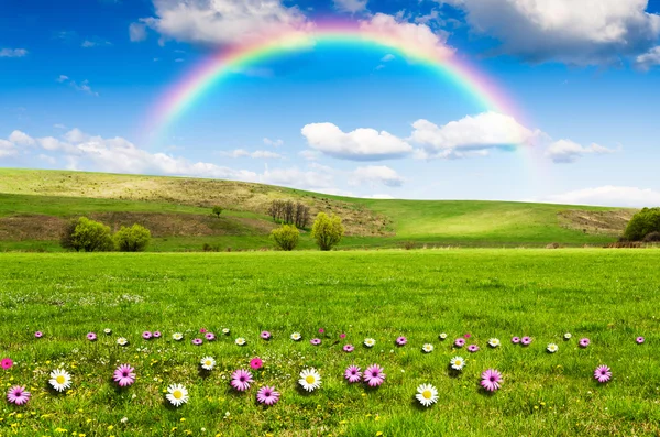 Sunny day with rainbow and fluffy white clouds — Stock Photo, Image