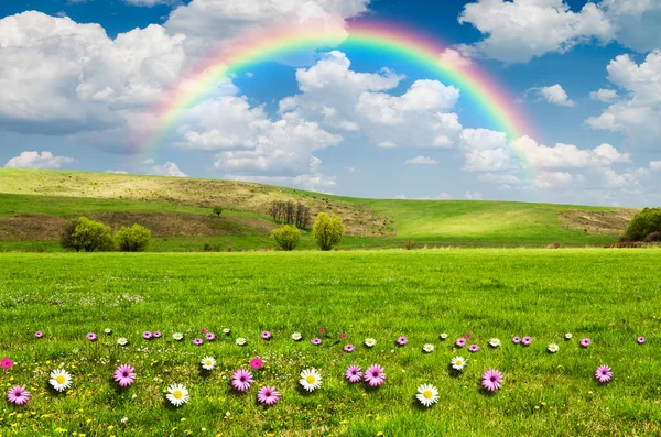 Sunny day with rainbow and fluffy white clouds — Stock Photo, Image