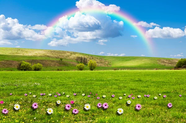 Sunny day with rainbow and fluffy white clouds — Stock Photo, Image