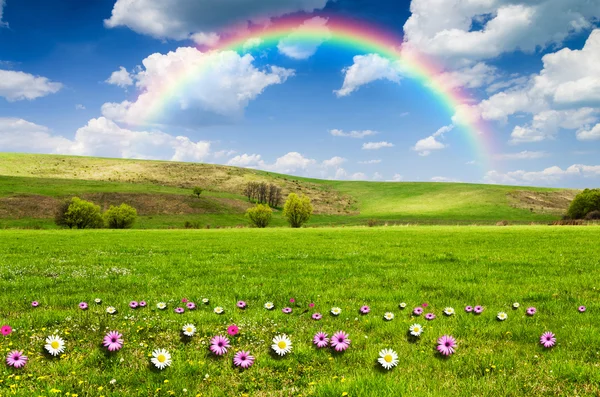 Sunny day with rainbow and fluffy white clouds — Stock Photo, Image