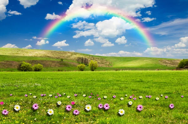 Sunny day with rainbow and fluffy white clouds — Stock Photo, Image