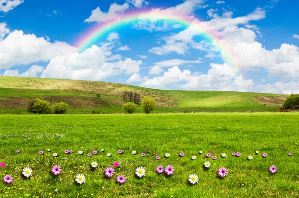 Sunny day with rainbow and fluffy white clouds — Stock Photo, Image