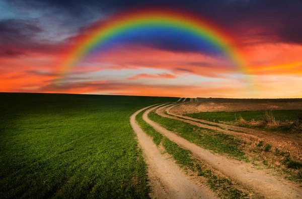 Сельская дорога и радуга ночью — стоковое фото