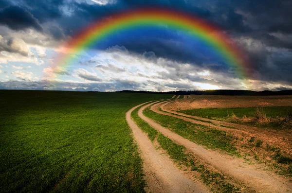 Landelijke weg en regenboog in de nacht — Stockfoto