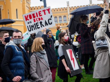 Wroclaw, Polonya, 23 Ekim 2020 - Polonya kenti Wroclaw 'da kadınların protestosu, çünkü Polonya' nın en üst mahkemesi kürtajı yasaklayan bir yasa çıkardı. Genç aktivist elinde bir poster tutuyor: Kadınlar ölmeyecek