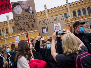Wroclaw, Polonya, 23 Ekim 2020 - Polonya kenti Wroclaw 'da kadınların protestosu, çünkü Polonya' nın en üst mahkemesi kürtajı yasaklayan bir yasa çıkardı. Genç aktivistler, içinde küfür içeren bir afiş tutuyor.