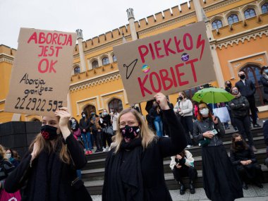 Wroclaw, Polonya, 23 Ekim 2020 - Polonya kenti Wroclaw 'da kadınların protestosu, çünkü Polonya' nın en üst mahkemesi kürtajı yasaklayan bir yasa çıkardı. Genç aktivistler, içinde küfür içeren bir afiş tutuyor.