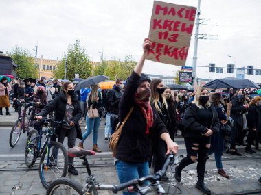 Wroclaw, Polonya, 23 Ekim 2020 - Polonya kenti Wroclaw 'da kadınların protestosu, çünkü Polonya' nın en üst mahkemesi kürtajı yasaklayan bir yasa çıkardı. Kadın elinde bir yazı olan bir poster tutuyor: Ellerinde kan var.