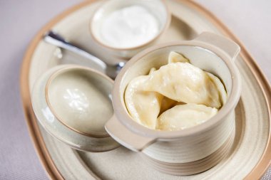 Ekşi kremayla servis edilen seramik bir kaba patates doldurulmuş Ukrayna usulü Rus cilası.