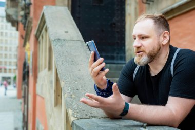 Yetişkin bir adamın akıllı telefondan bir görüntülü araması var. Şehirdeki bir akıllı telefondan konuşuyor. 