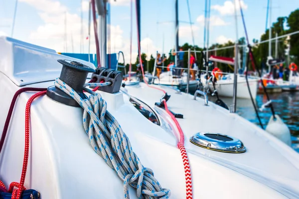 Detail of a sailboat deck with a winch and nylon ropes. Sailing yacht rigging equipment