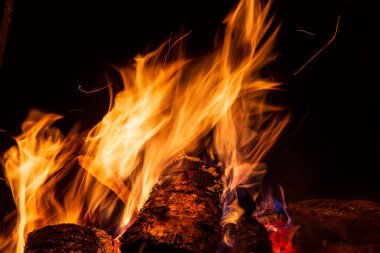 Boş yeri olan bir gece kamp ateşi. Siyah arka plana karşı büyük şenlik ateşi. Şenlik ateşi kıvılcımları yakın