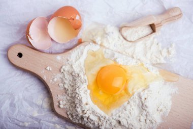 Tahta kesme tahtasına un ve yumurta sarısı, yakın plan fotoğraf.