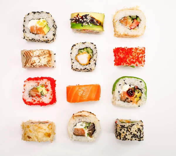 various sushi on white background, top view. maki sushi with seafood, salmon, shrimp, avocado and cucumber