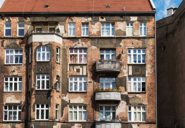 Eski püskü bina cephesi, eski pencereler. Avrupa 'daki eski apartman binasının ön cephesi