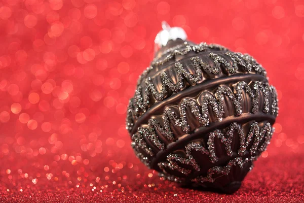 Feestelijke vintage decoratie Kerstbal op glitter rode achtergrond. seizoensgebonden wintervakantie — Stockfoto