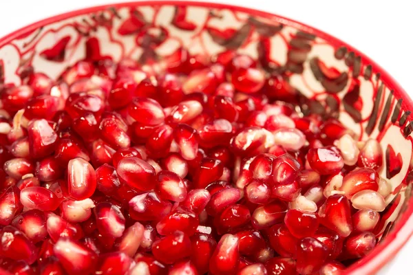 Pomegranate seeds are in a red bowl on white background — Stock Photo, Image