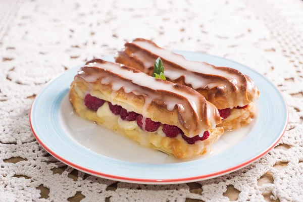 Eclairs with raspberries — Stock Photo, Image