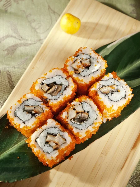 Rolos de sushi em placa de madeira — Fotografia de Stock