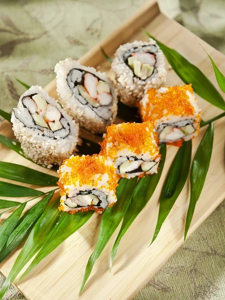 Rollos de sushi en una tabla de madera — Foto de Stock