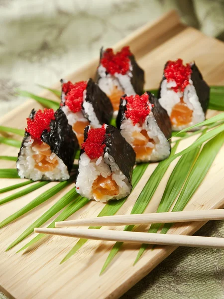 Rollos de sushi en una tabla de madera — Foto de Stock