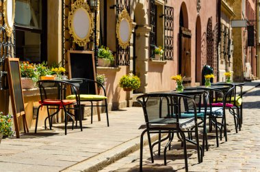 Atlar ve at arabalarıyla süslü fresklerin, kuşlarla süslü dekoratif panellerin ve bir çatı altında klasik dikdörtgen pencerelerin yer aldığı tarihi bir Avrupa binası.