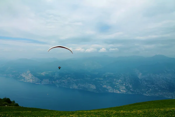 Parapente sobre lago e montanhas — Fotografia de Stock