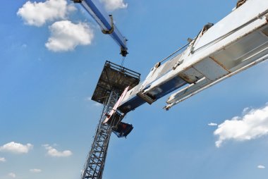 Mavi gökyüzü arka plan karşı yüksek bina vinç