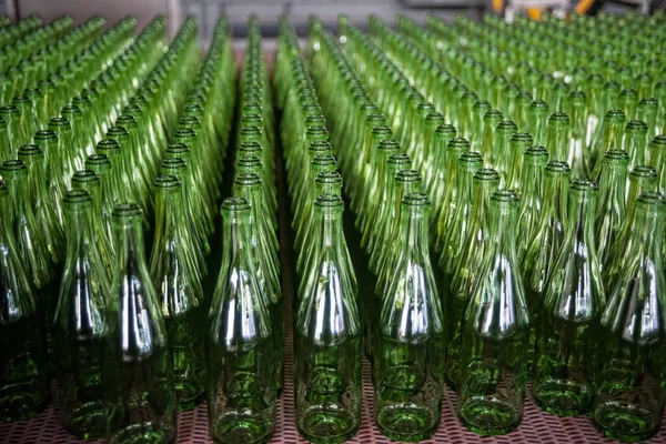 Many bottles on conveyor belt in glass factory