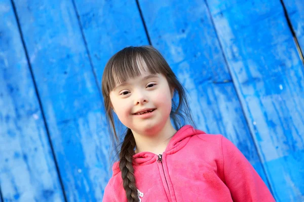 Jeune fille souriant sur le fond du mur bleu — Photo