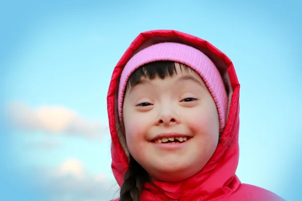 Menina sorrindo no fundo do céu azul — Fotografia de Stock