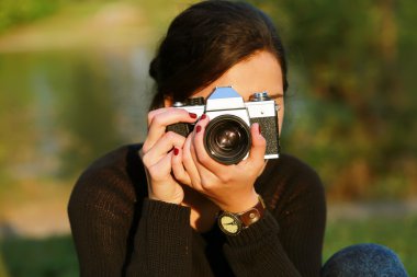 Genç kadın bir eski fotoğraf makinesi ile fotoğraf çekimi